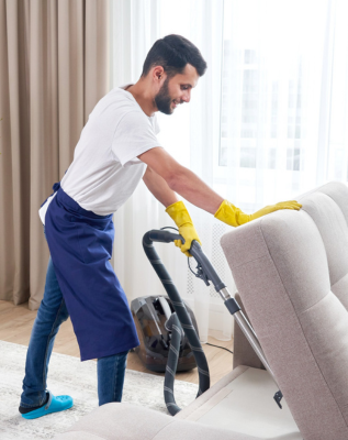 Cleaner Dallas professional cleaner vacuuming and deep cleaning a living room sofa