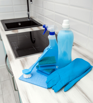 Cleaning supplies and gloves on kitchen counter used by Cleaner Dallas for home cleaning services.