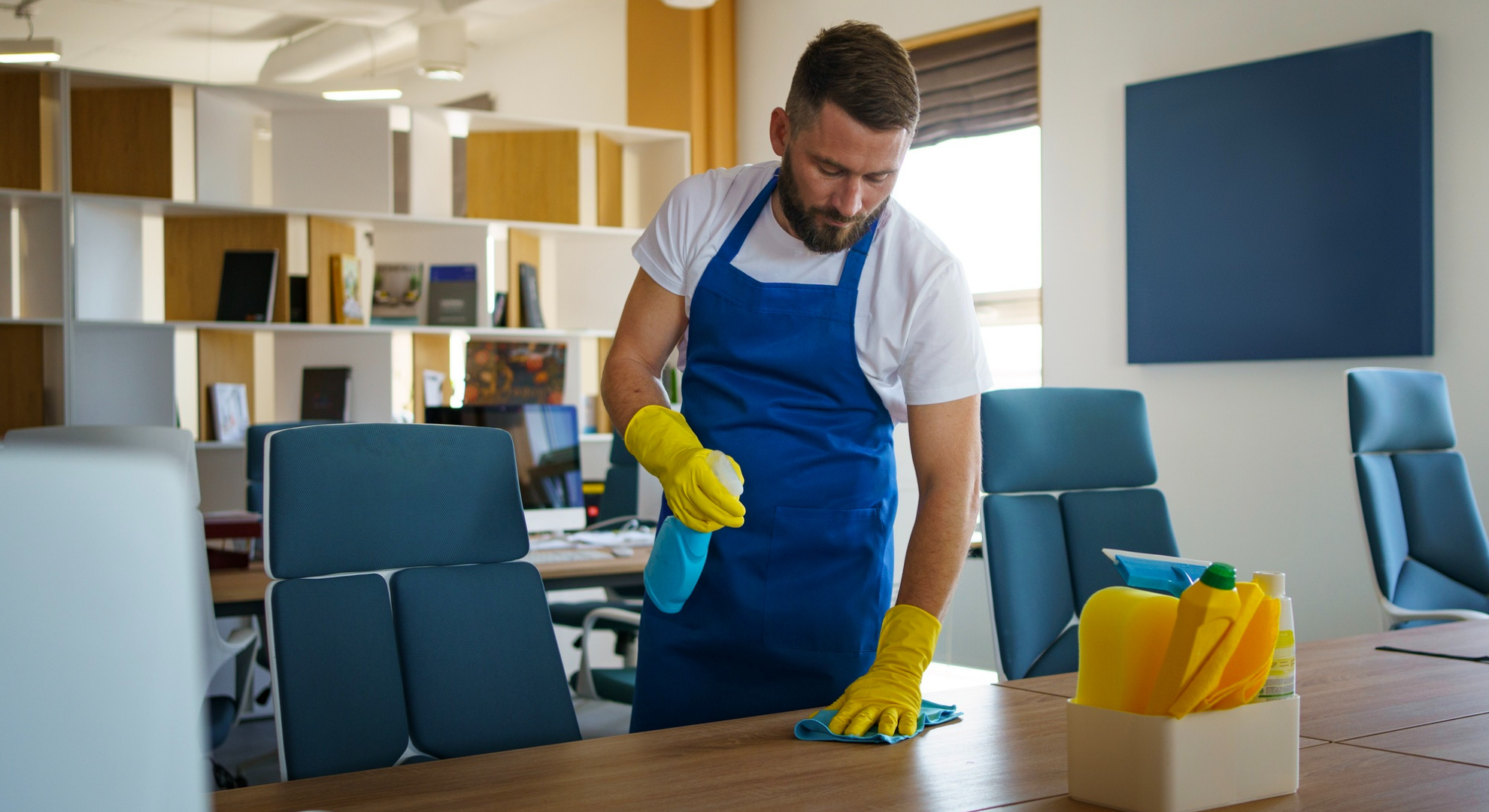 Cleaner Dallas professional office cleaner disinfecting desk surfaces in a modern workspace