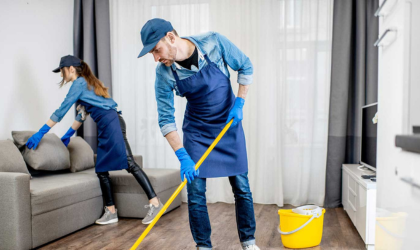 Cleaner Dallas team mopping floors and tidying living room during home cleaning service