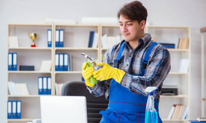 Cleaner Dallas professional sanitizing office faucet during detailed commercial cleaning service.