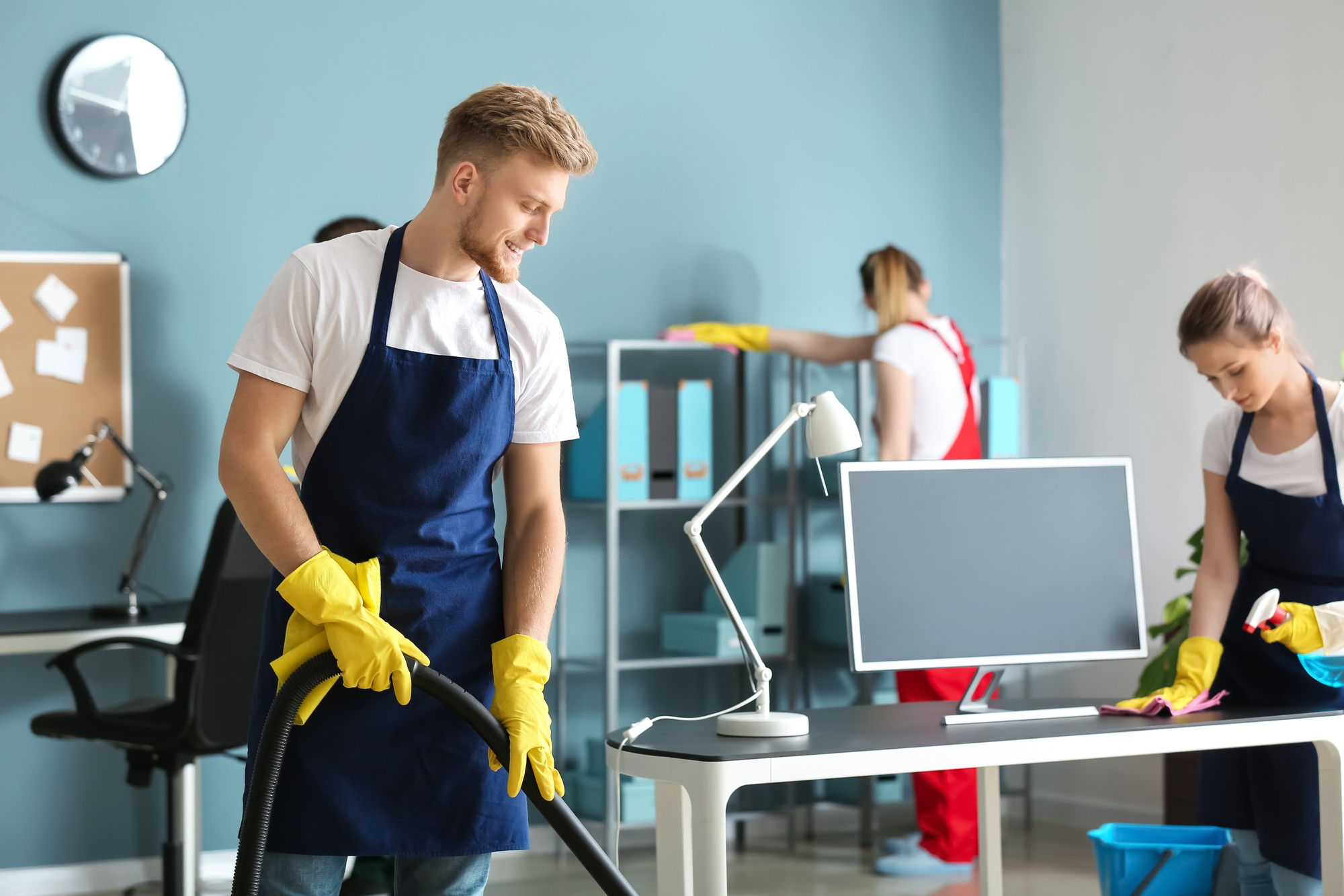 Cleaner Dallas commercial cleaning team vacuuming and sanitizing office desks and workstations